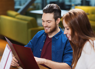 Image showing smiling couple with menus at restaurant