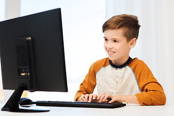 Image showing smiling boy with computer at home