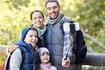 Image showing happy family with smartphone selfie stick in woods