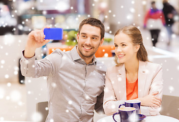 Image showing happy couple with smartphone taking selfie in mall