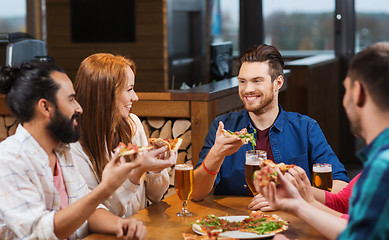 Image showing friends eating pizza with beer at restaurant