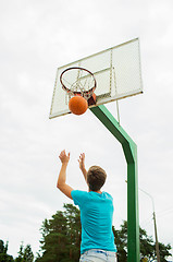 Image showing young man playing basketball outdoors