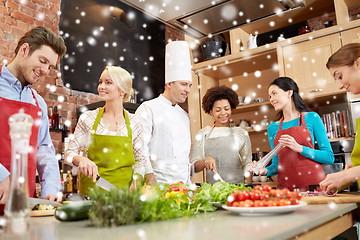 Image showing happy friends and chef cook cooking in kitchen