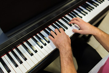 Image showing close up of male hands playing piano