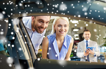 Image showing happy couple with car dealer in auto show or salon