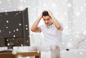 Image showing disappointed man watching tv at home