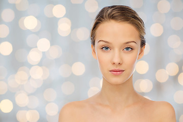 Image showing young woman face with bare shoulders over lights