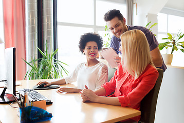 Image showing happy creative team with computer in office