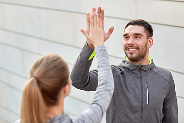 Image showing happy couple giving high five outdoors