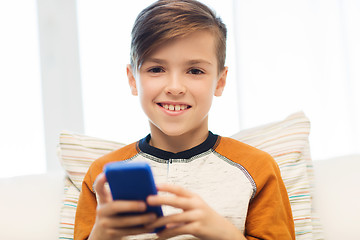 Image showing boy with smartphone texting or playing at home