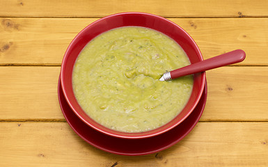 Image showing Spoon in a full bowl of green soup