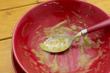 Image showing Dregs of pea and ham soup in a red bowl