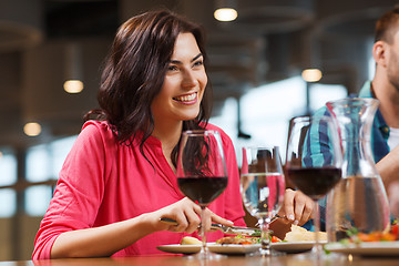 Image showing happy woman having dinner at restaurant