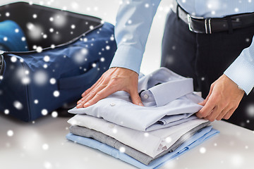 Image showing businessman packing clothes into travel bag