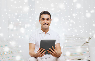 Image showing smiling man working with tablet pc at home