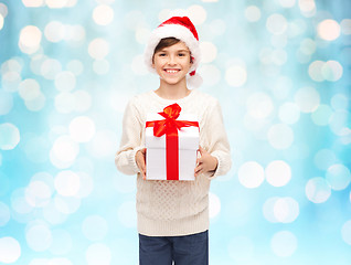 Image showing smiling happy boy in santa hat with gift box