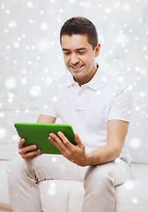 Image showing smiling man working with tablet pc at home