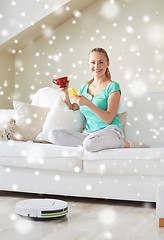 Image showing happy woman with smartphone drinking tea at home