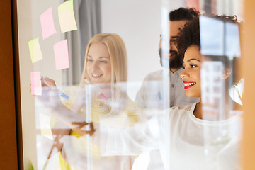 Image showing happy creative team writing on stickers at office