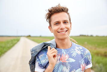 Image showing smiling young hippie man on country road