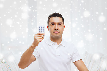 Image showing man showing pack of pills at home