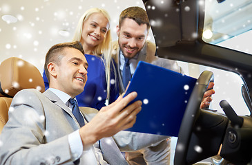 Image showing happy couple with car dealer in auto show or salon