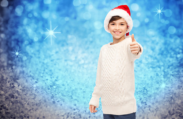 Image showing smiling happy boy in santa hat showing thumbs up