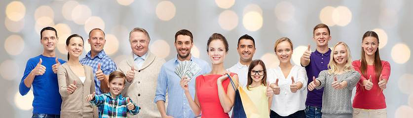 Image showing happy people with shopping bags showing thumbs up