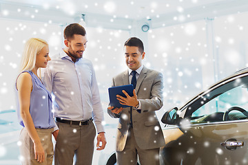 Image showing happy couple with car dealer in auto show or salon