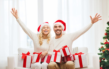 Image showing happy couple at home with christmas gift boxes