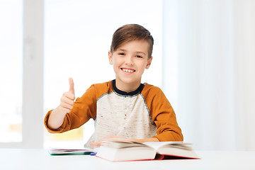 Image showing happy student boy with textbook showing thumbs up