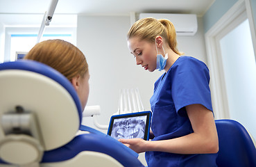 Image showing dentist showing x-ray on tablet pc to patient girl