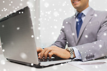 Image showing close up of businessman with laptop and papers