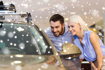 Image showing happy couple buying car in auto show or salon