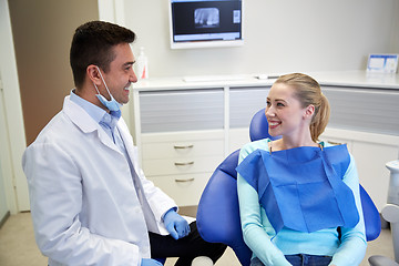 Image showing happy male dentist with woman patient at clinic