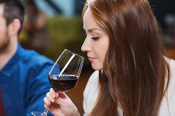 Image showing smiling woman drinking red wine at restaurant