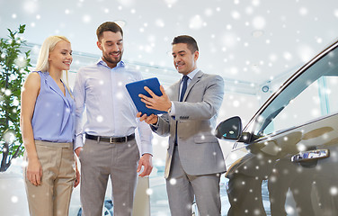 Image showing happy couple with car dealer in auto show or salon