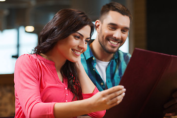 Image showing smiling couple with menus at restaurant