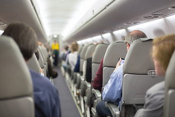 Image showing Stewardessand passengers on commercial airplane.