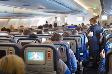 Image showing Stewardessand passengers on commercial airplane.