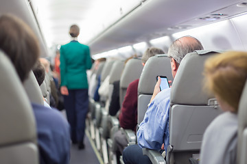 Image showing Stewardessand passengers on commercial airplane.