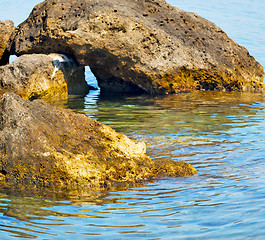 Image showing brown  stone in the coastline sunrise and light ocean white sky