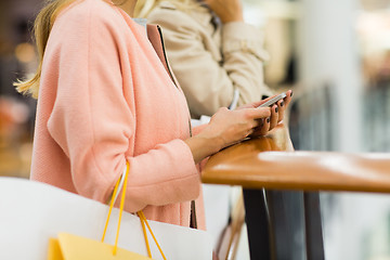 Image showing close up of woman with smartphone and shopping bag