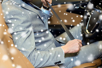 Image showing close up of man fastening seat safety belt in car