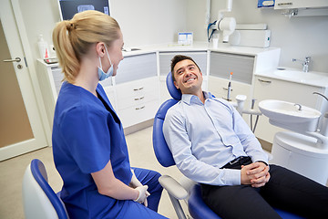 Image showing happy female dentist with man patient at clinic