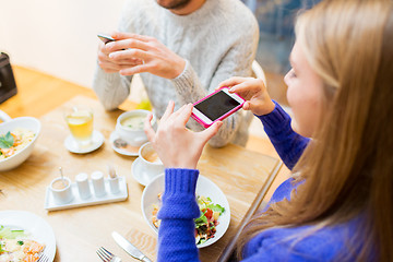 Image showing friends with smartphones taking picture of food