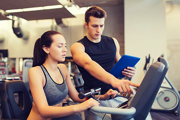 Image showing woman with trainer on exercise bike in gym