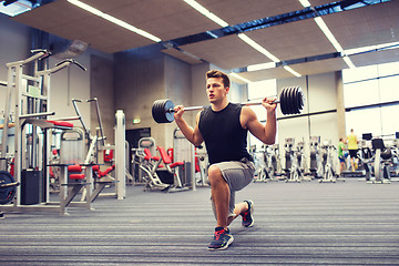 Image showing young man flexing muscles with barbell in gym