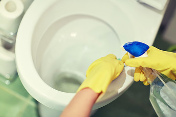 Image showing close up of hand with detergent cleaning toilet