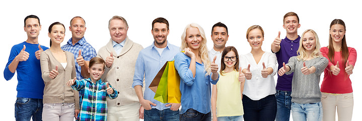 Image showing happy people with shopping bags showing thumbs up